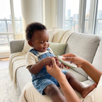 Parent filing baby's nails with grinder - lifestyle