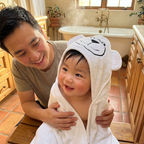 Father wrapping baby in Bubzies hooded towel after bath