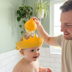 Father rinsing baby's hair with Bubzies tear-free visor cap