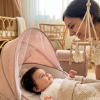 Baby gazing up at the Bubzies crib mobile in a honey-oat boho nursery